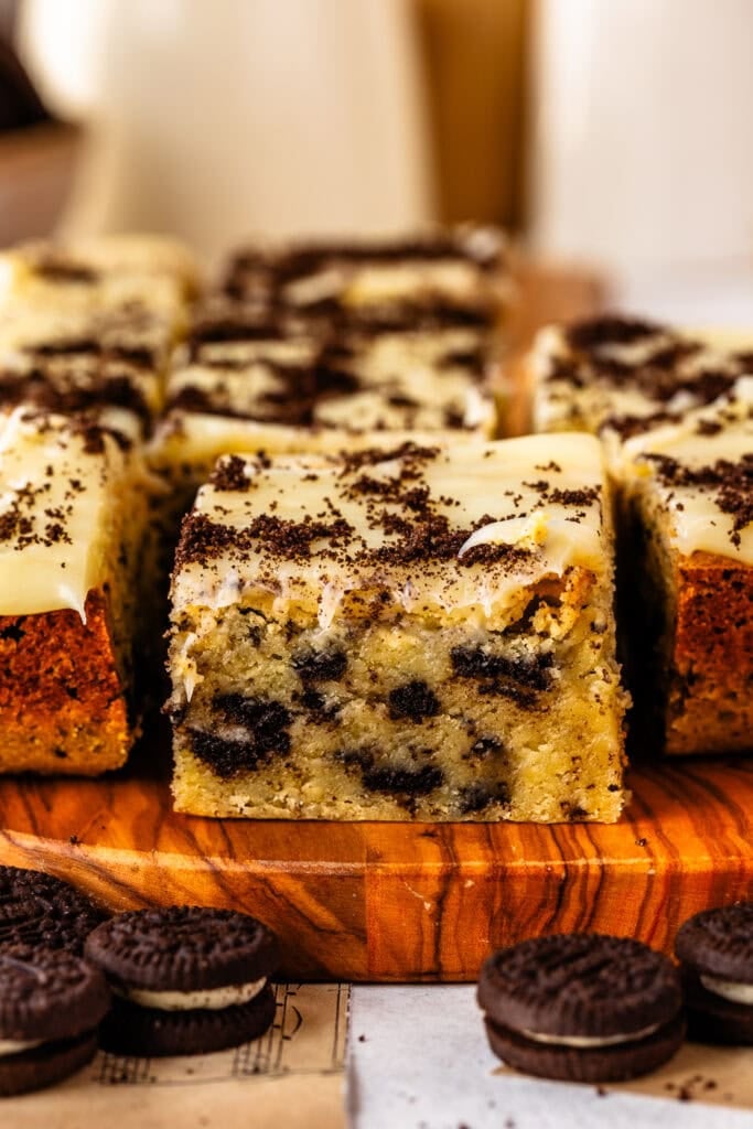 Soft and gooey cookies and cream blondie bars on a wooden serving board.