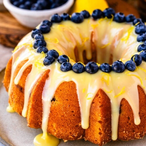 Lemon blueberry bundt cake drizzled with lemon white chocolate ganache and fresh blueberries.