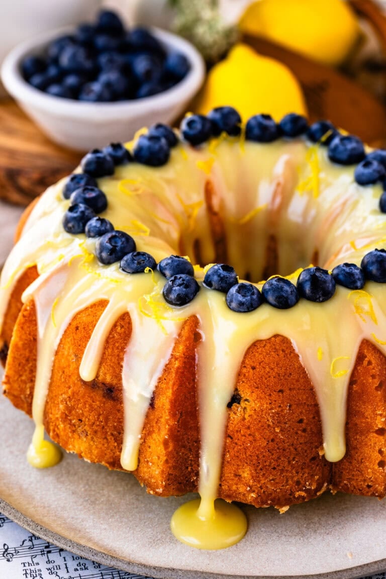 Lemon blueberry bundt cake drizzled with lemon white chocolate ganache and fresh blueberries.