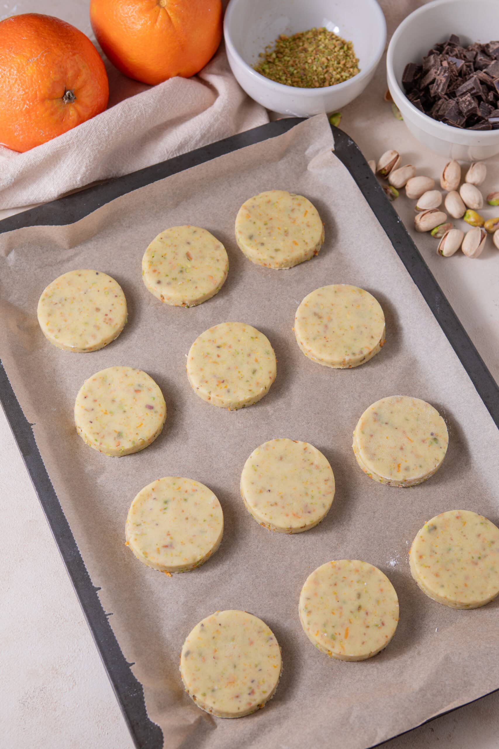 Unbaked orange pistachio shortbread cookies on a baking sheet