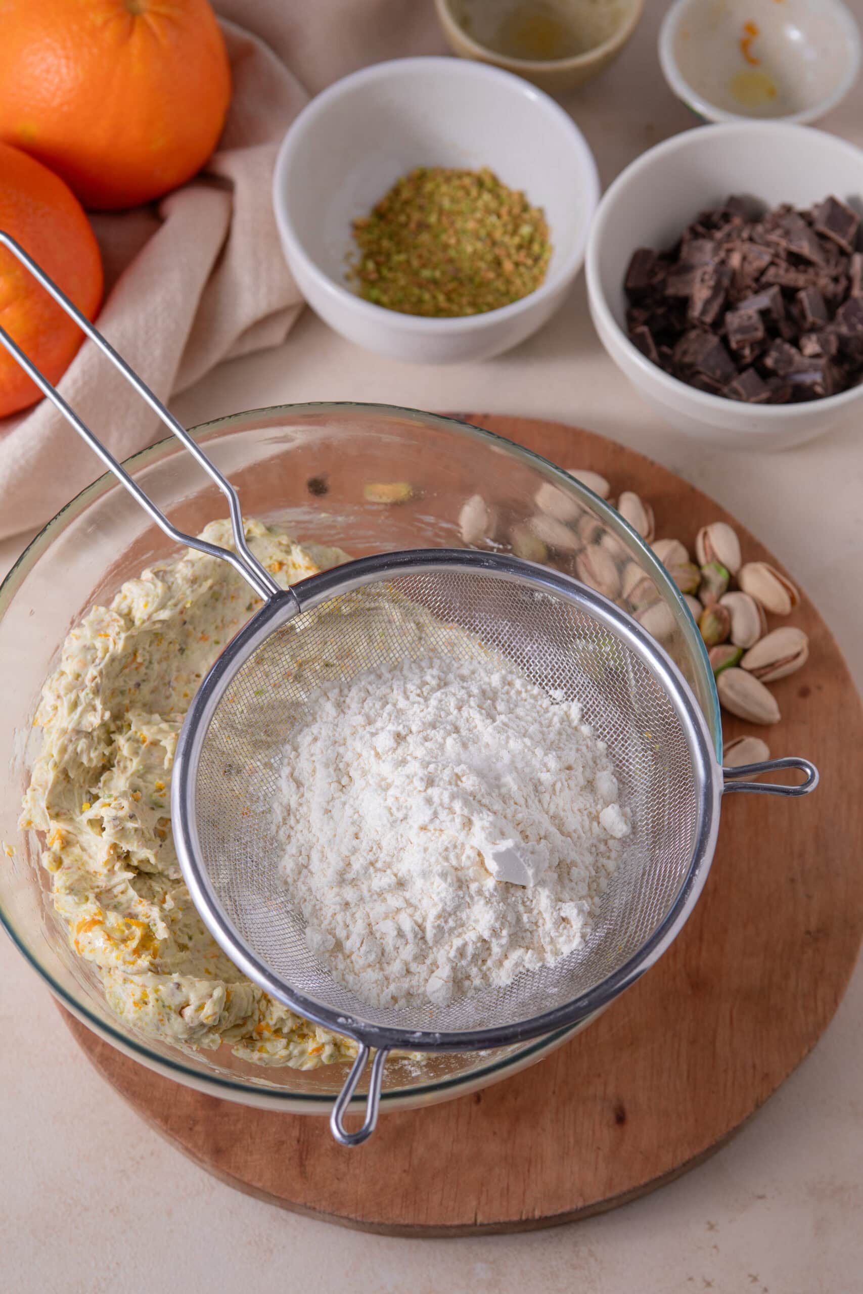 Sifting flour into orange pistachio shortbread cookie dough