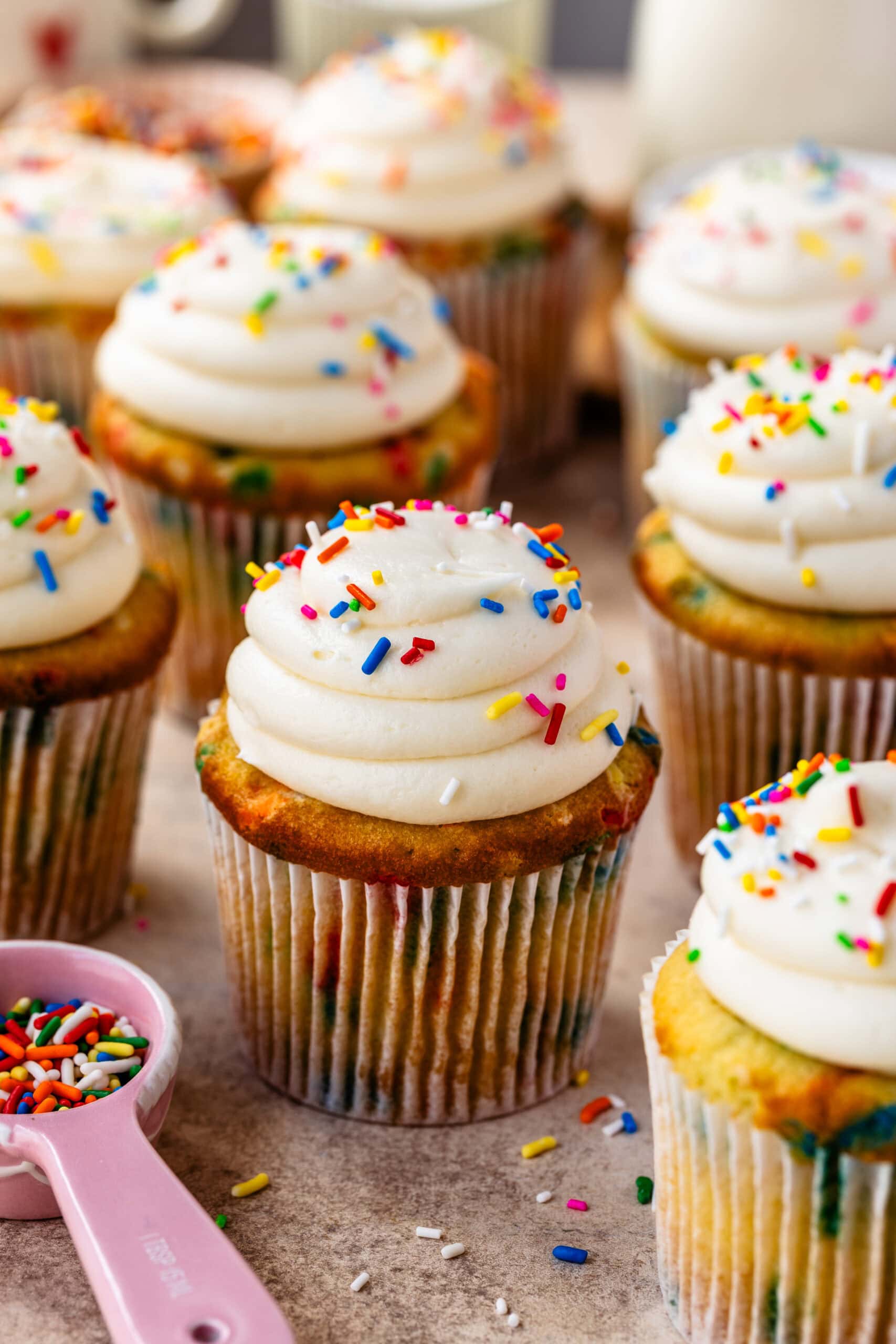 Colorful cupcakes with white frosting and rainbow sprinkles for dessert.