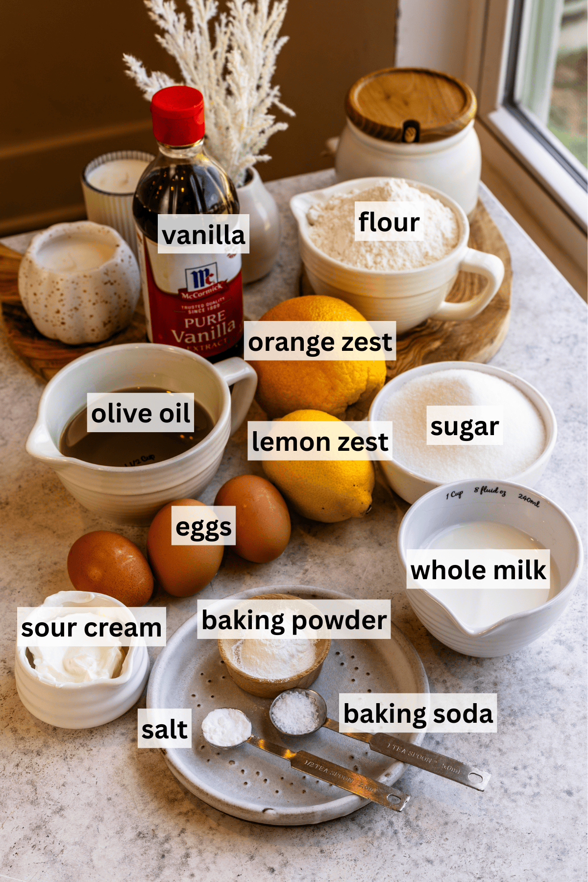 Ingredients for olive oil cake on a granite surface.