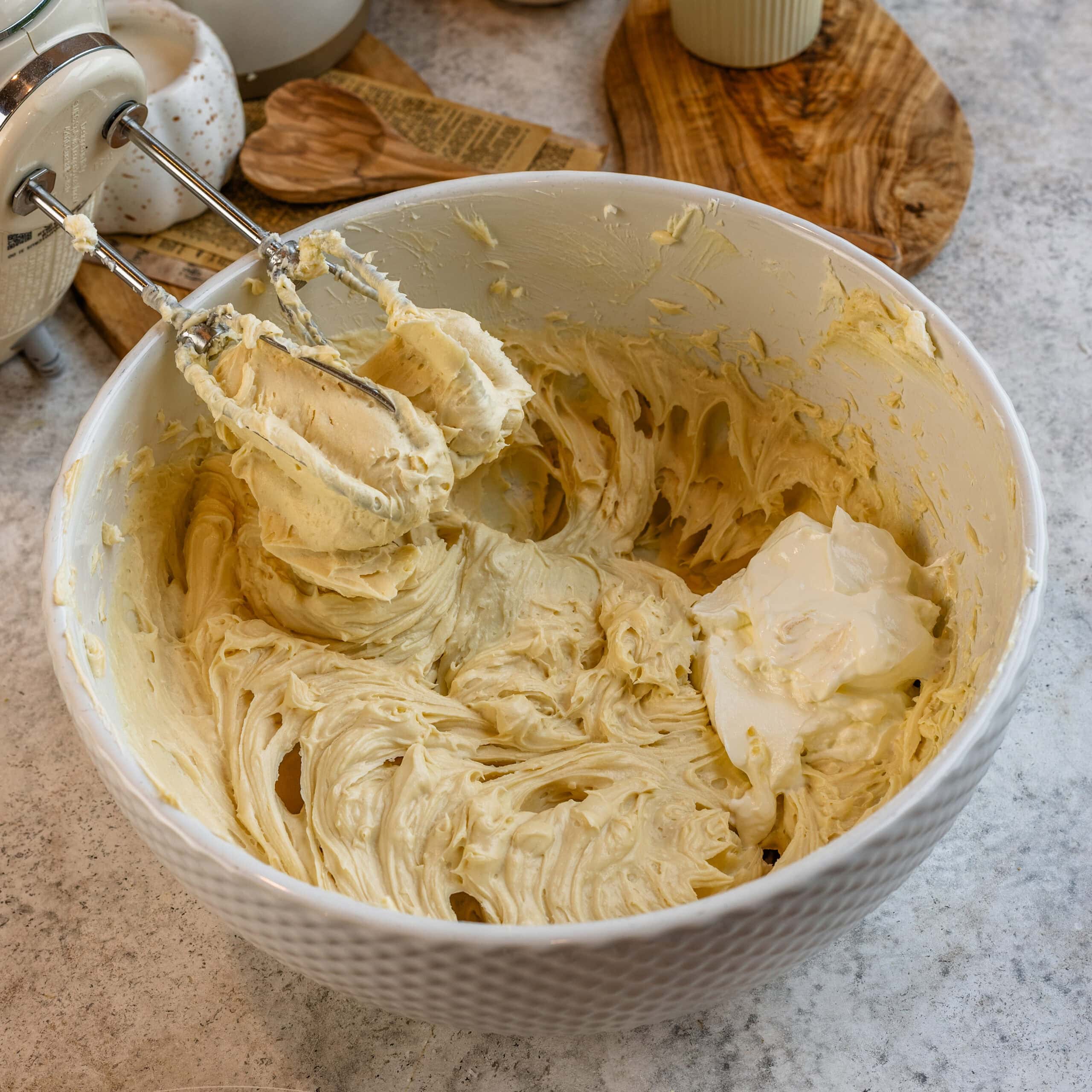 Cream cheese cheesecake filling mixed with brown sugar and sour cream in a large mixing bowl.