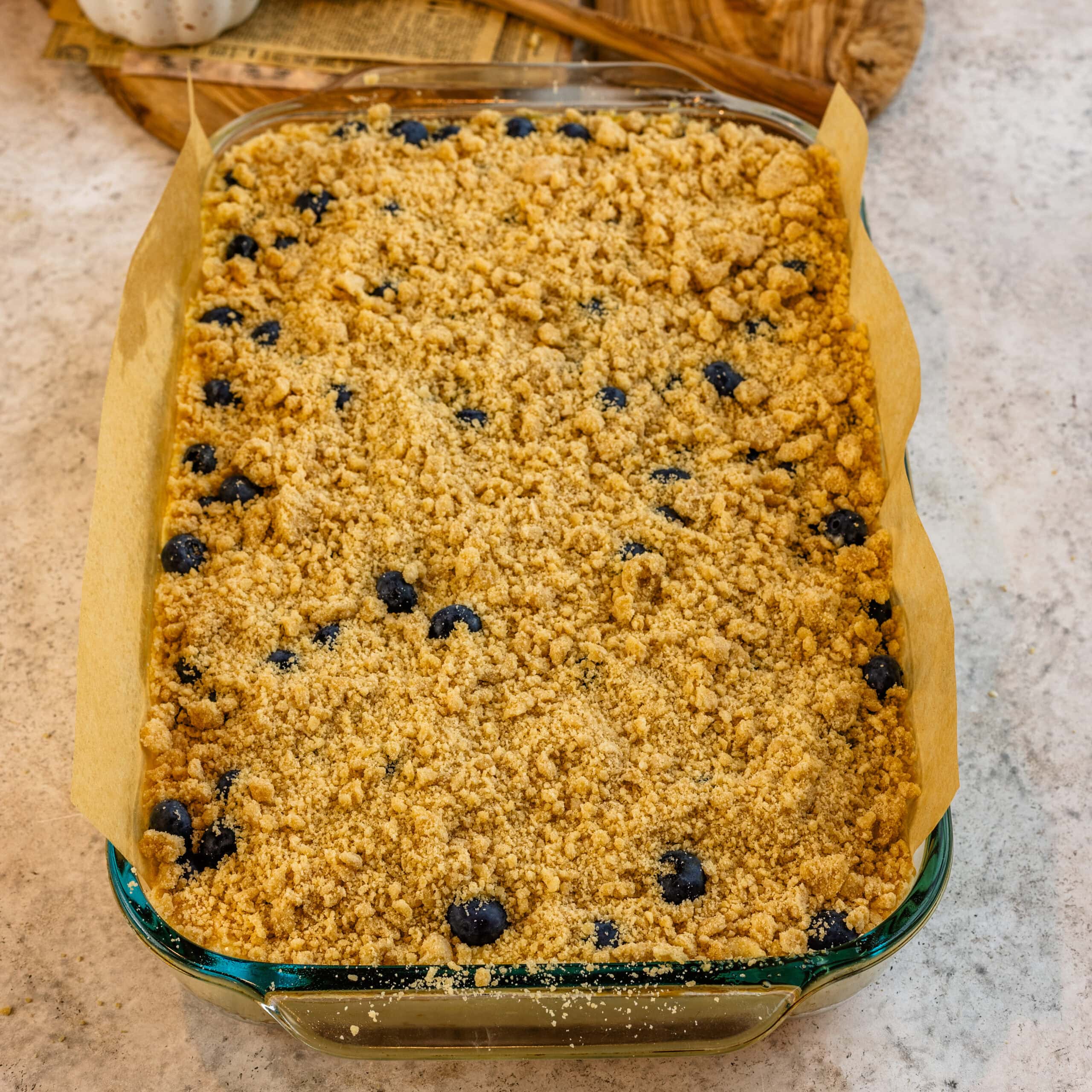 Blueberry cheesecake bars topped with buttery streusel before baking.