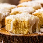 Coconut Blondie with a bite taken out, showing the soft, fudgy center and coconut white chocolate ganache.
