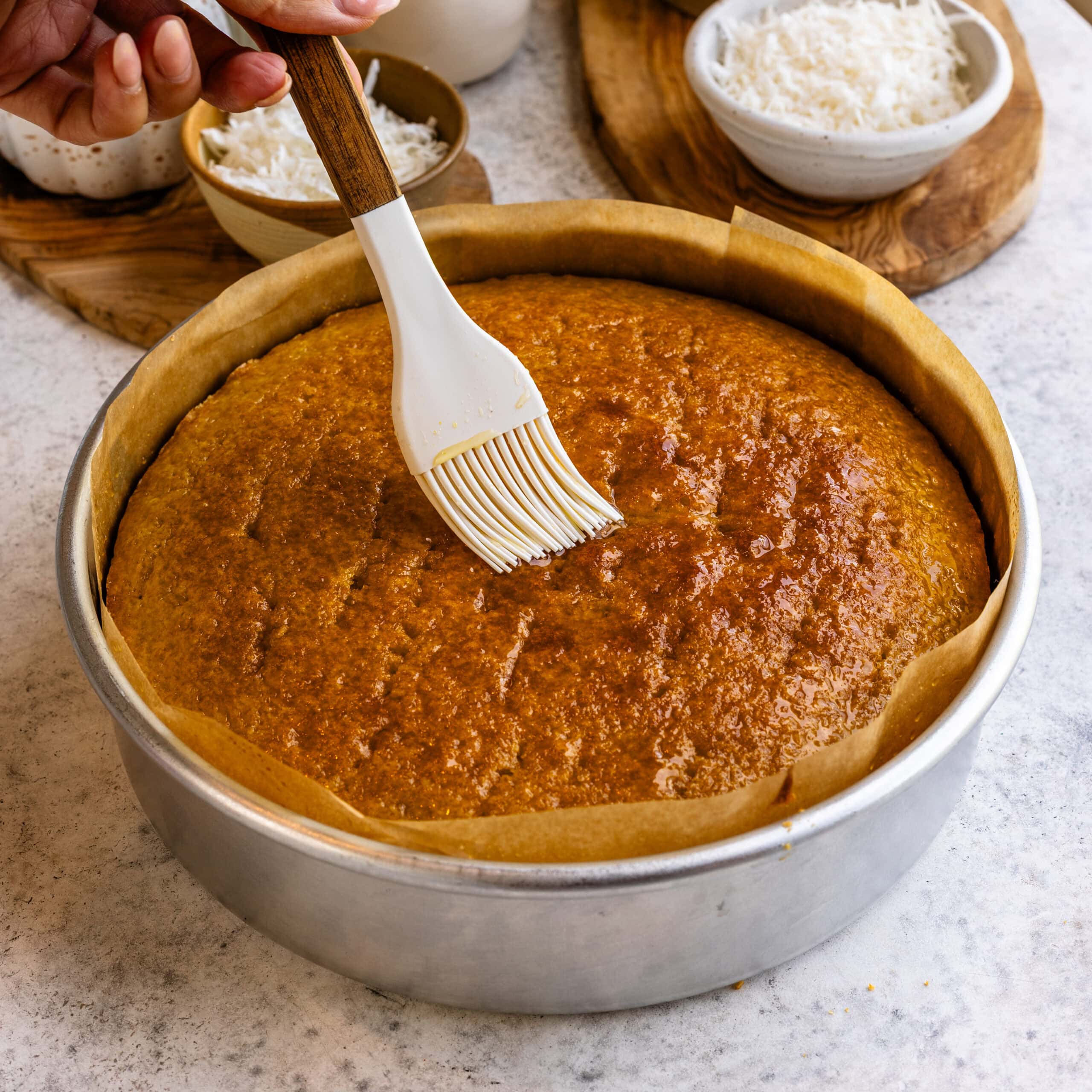 Orange syrup being brushed onto the olive oil cake to make it nice and moist.