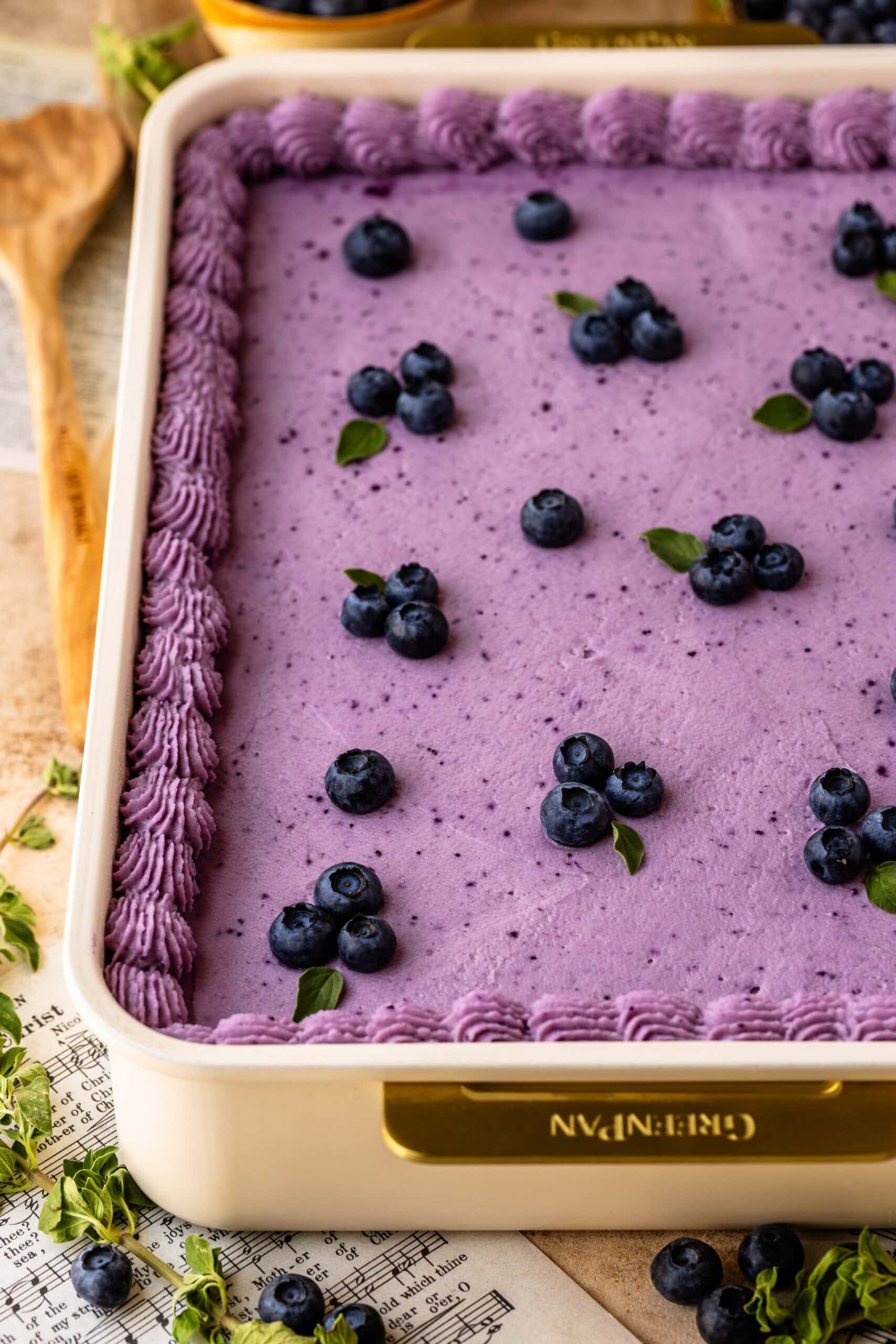 Blueberry Chantilly Sheet Cake frosted with blueberry Chantilly frosting and decorated with fresh blueberries.