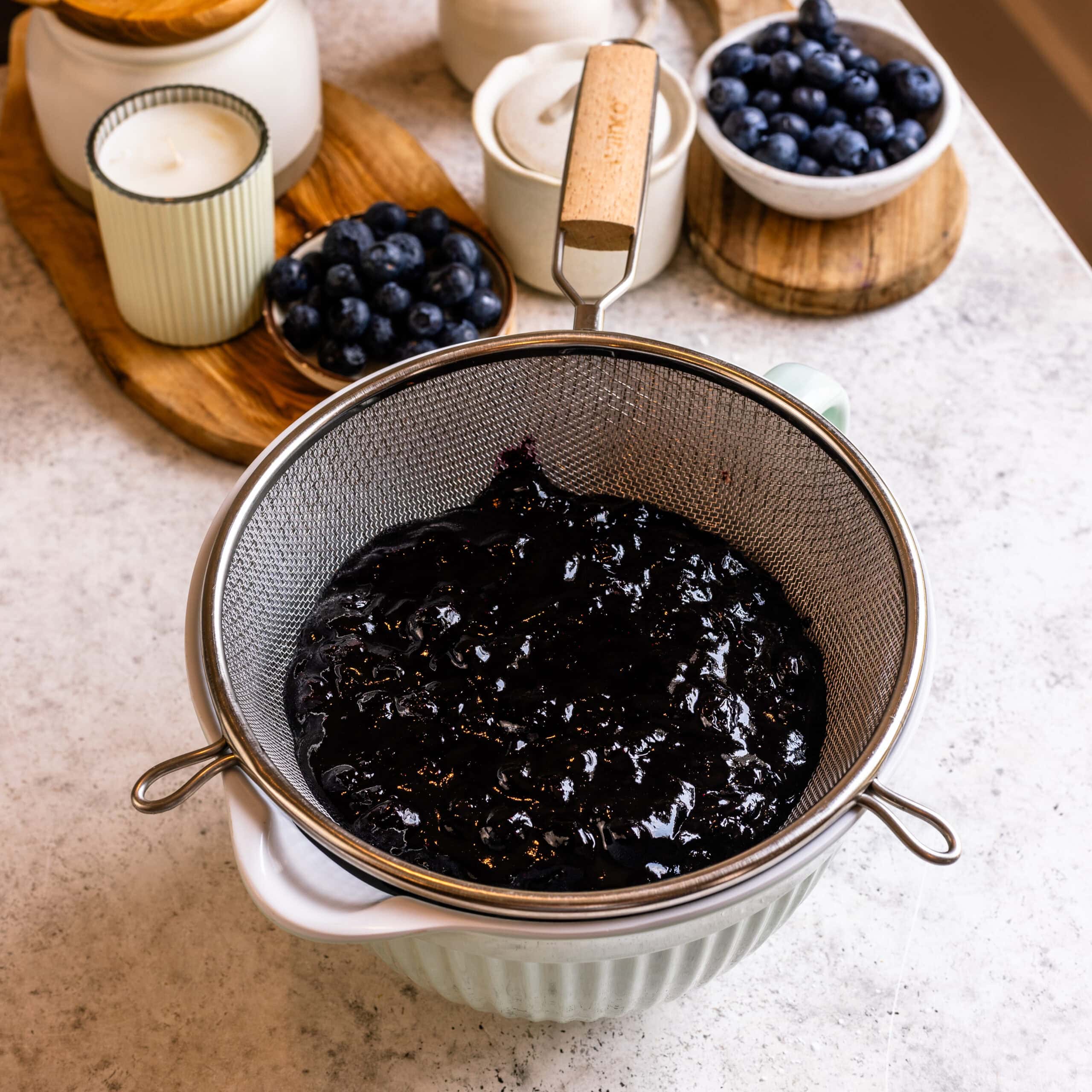 Blueberry sauce in a strainer.