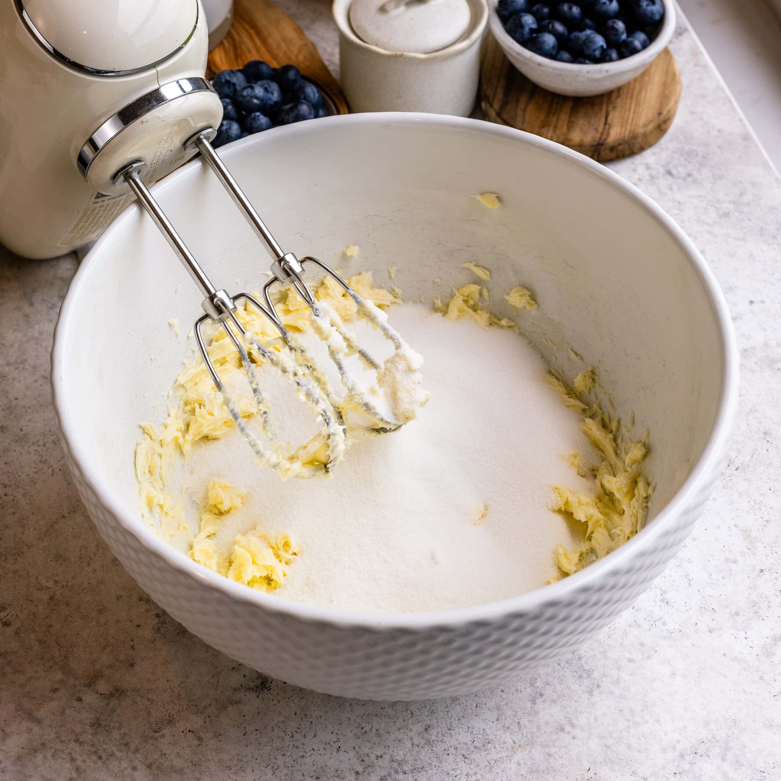 A mixing bowl full of creamed butter and granulated sugar ready to be mixed in.