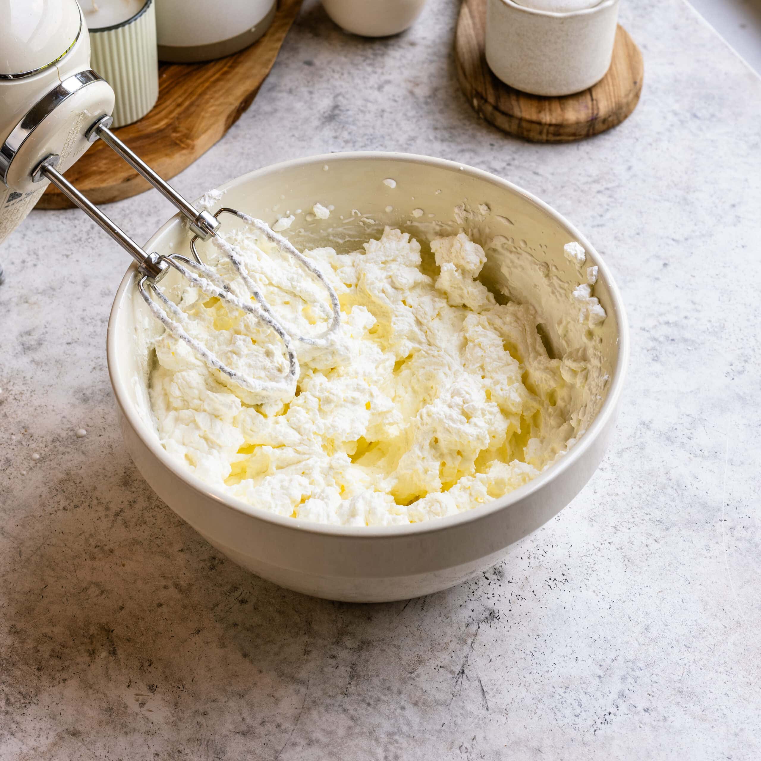A bowl of freshly whipped cream in a white mixing bowl.