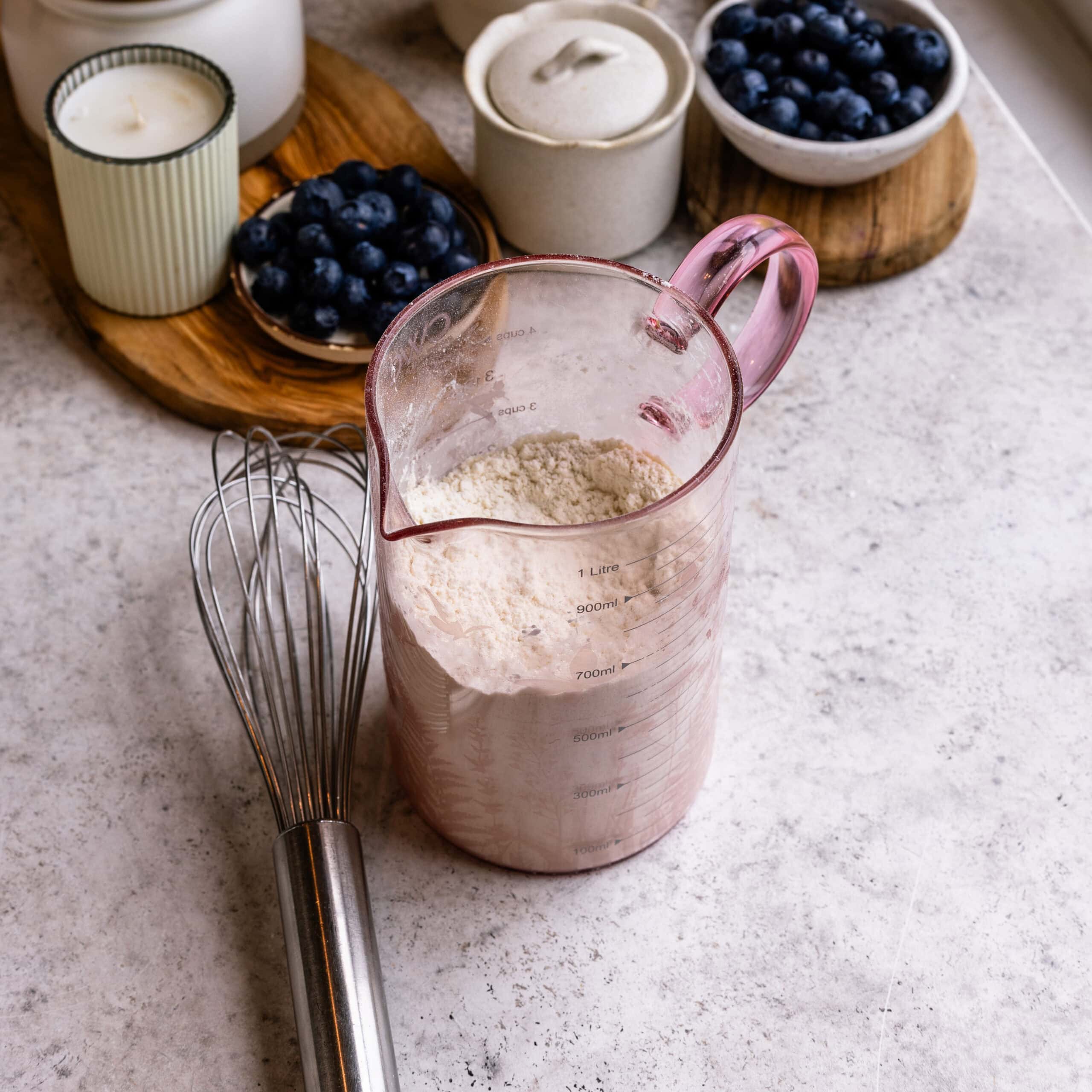 Dry ingredients for Blueberry Sheet Cake in a large measuring cup.
