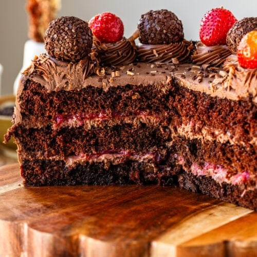 Half of a Chocolate Strawberry Cake on a serving plate showing the layered strawberry filling and chocolate cake.