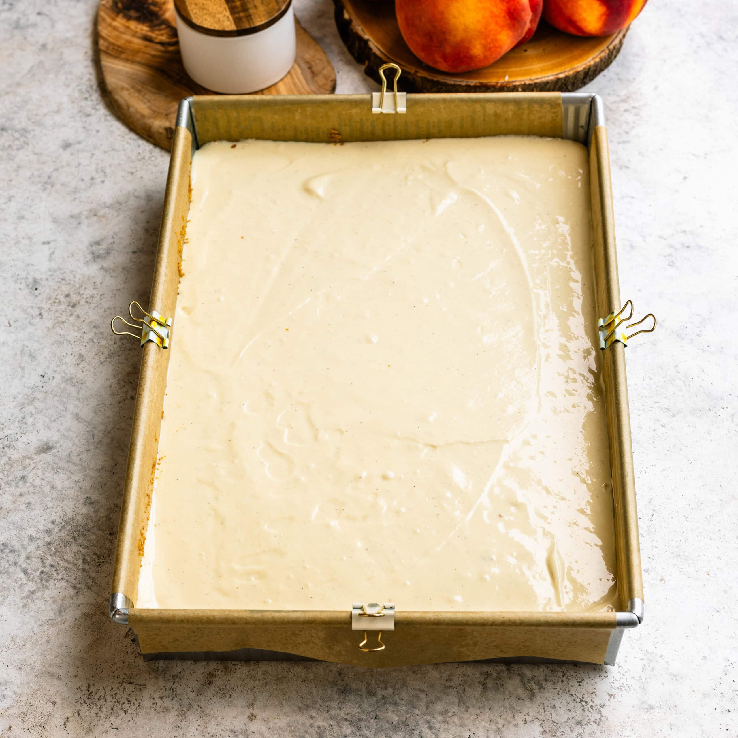 The cheesecake layer after being added to the baking pan.