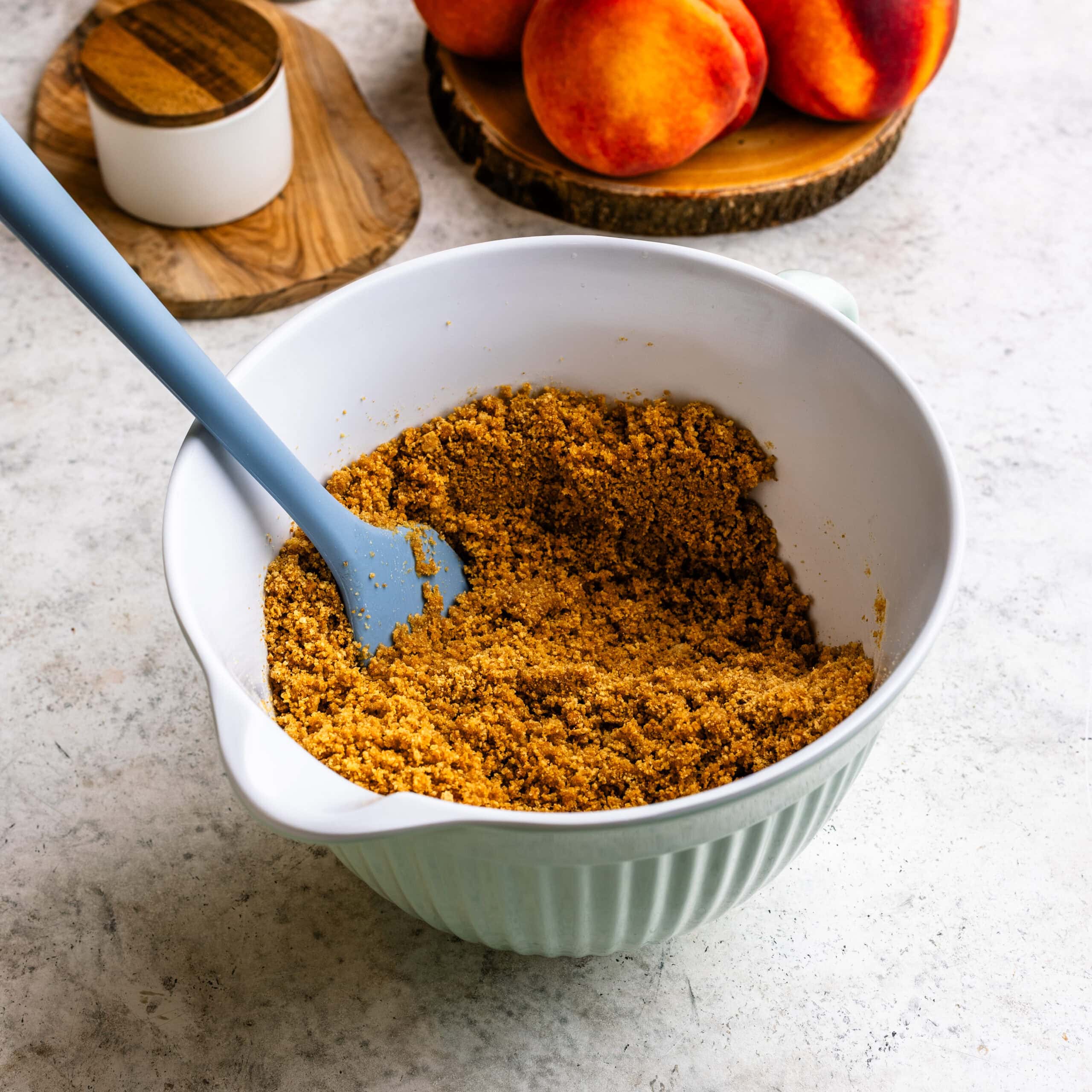 Mixed graham cracker crust in a mixing bowl, ready to press into a baking pan.