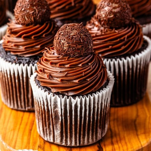 Brigadeiro Cupcakes topped with silky chocolate Briganache frosting, chocolate sprinkles, and a classic brigadeiro.