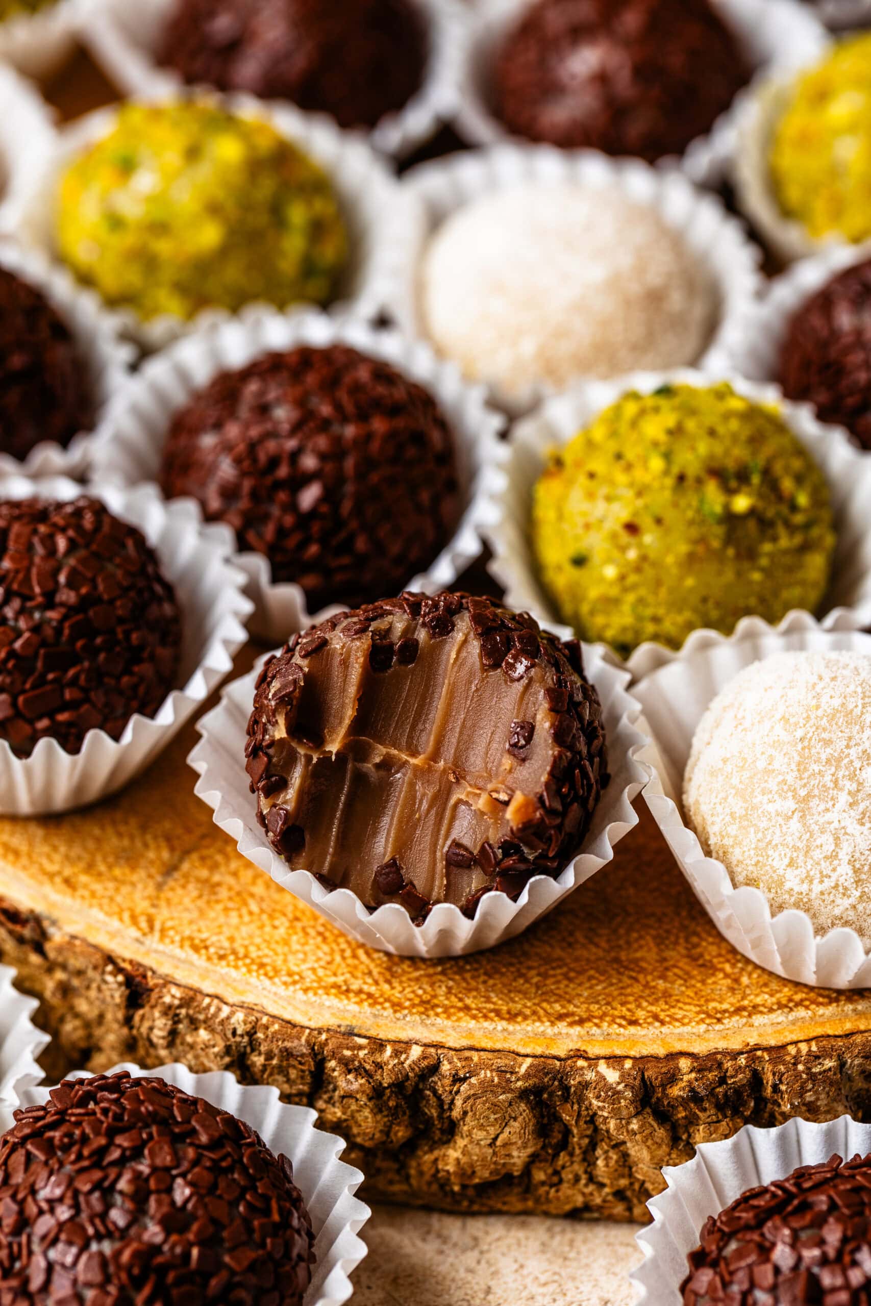 Chocolate brigadeiro with a bite taken out showing the soft and fudgy center.