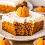 Slice of pumpkin sheet cake topped with cream cheese frosting and a pumpkin brigadeiro.
