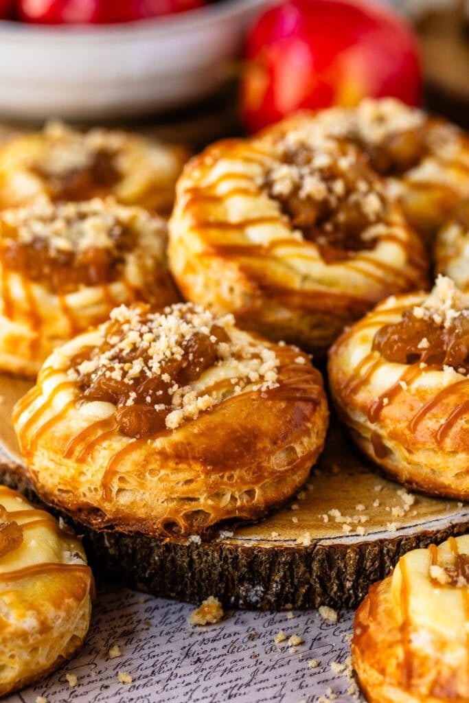 Homemade apple Danish pastries filled with cream cheese and spiced apples, topped with streusel and caramel drizzle.